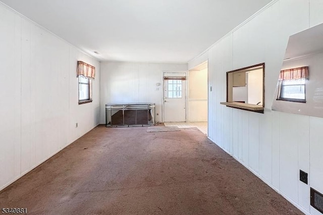 unfurnished living room with plenty of natural light and carpet