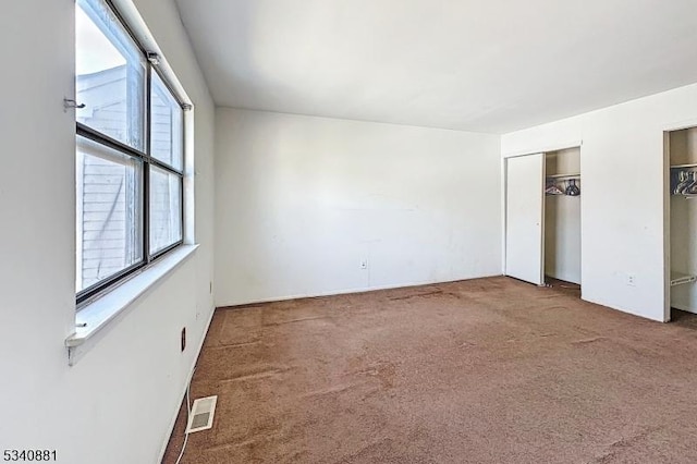 unfurnished bedroom featuring carpet and visible vents