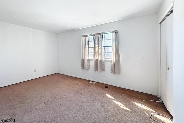 unfurnished room featuring carpet flooring and visible vents