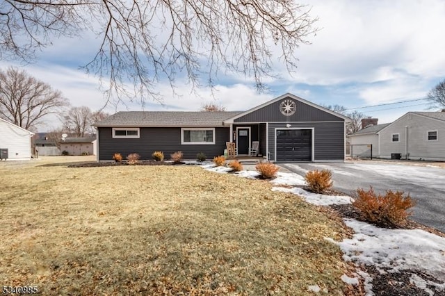 ranch-style house featuring a garage, driveway, and a front lawn