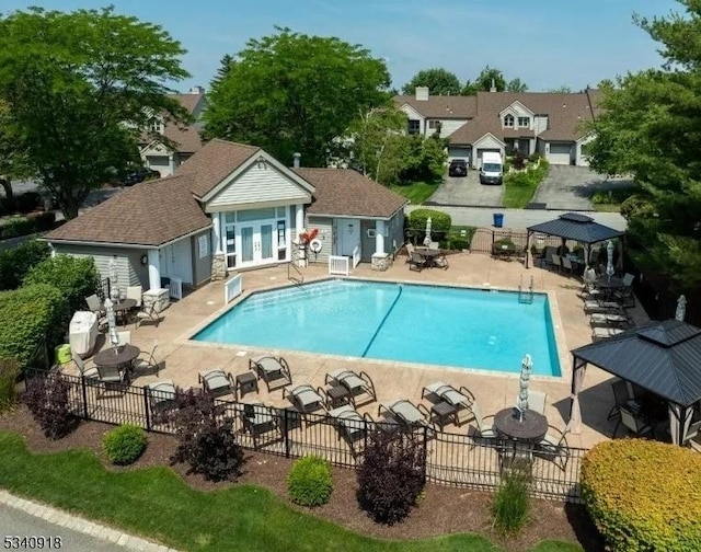 community pool with a patio area, fence, french doors, and a gazebo