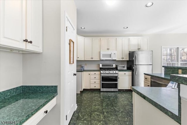 kitchen with appliances with stainless steel finishes, dark countertops, and recessed lighting