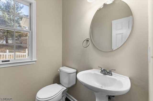 bathroom featuring baseboards, a sink, and toilet