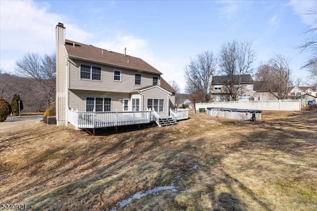 back of house with a chimney, fence, a deck, and a fenced in pool