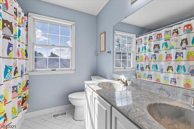 bathroom with a wealth of natural light, a sink, visible vents, and tile patterned floors