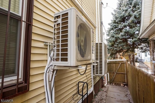 view of side of property featuring ac unit and fence