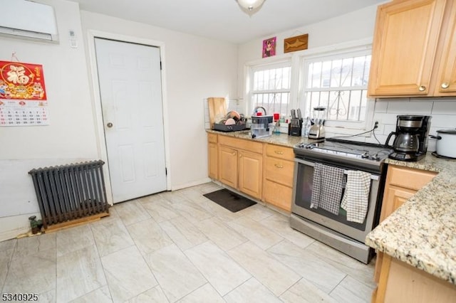 kitchen with light stone counters, an AC wall unit, stainless steel electric range, light brown cabinetry, and radiator heating unit