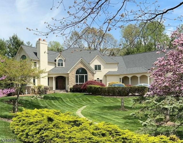 35 Geiger Ln, Warren Twp, NJ 07059 - view of front of property with stone siding, a chimney, a front lawn, and stucco siding
