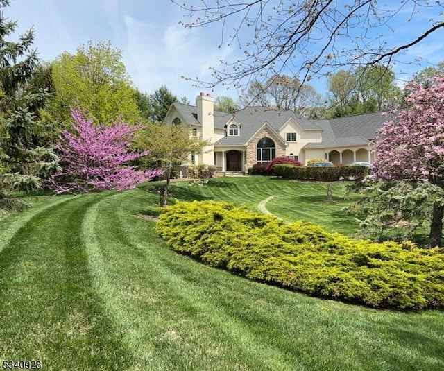 35 Geiger Ln, Warren Twp, NJ 07059 - view of front of house with a front yard, a chimney, and stone siding