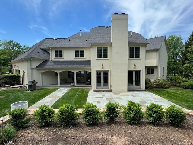 35 Geiger Ln, Warren Twp, NJ 07059 - rear view of property featuring french doors, stucco siding, a chimney, a patio area, and a lawn
