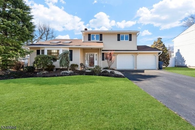 traditional-style home featuring a garage, driveway, and a front yard