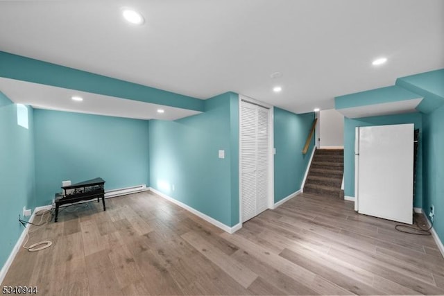 finished below grade area featuring recessed lighting, wood finished floors, baseboards, and stairs