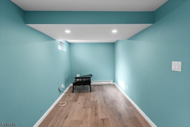 interior space with baseboard heating, recessed lighting, wood finished floors, and baseboards