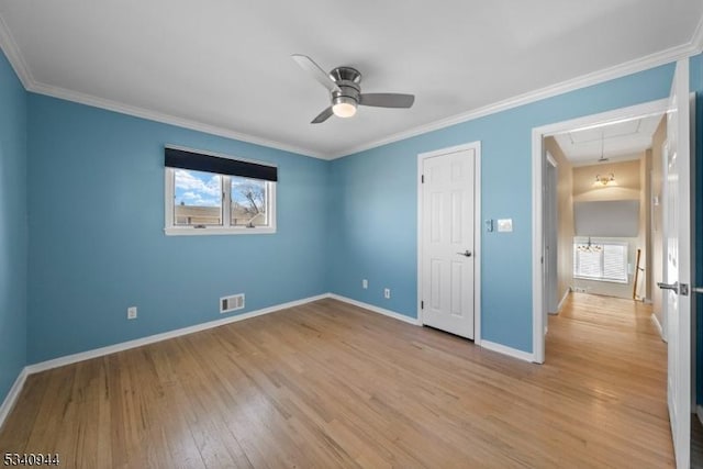 unfurnished bedroom with light wood-type flooring, attic access, multiple windows, and visible vents