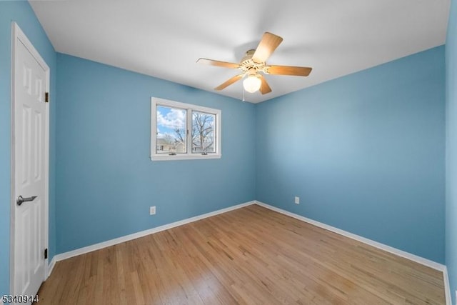 unfurnished bedroom with ceiling fan, wood finished floors, and baseboards