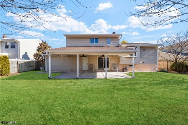 rear view of property with ceiling fan, fence, a patio, and a yard