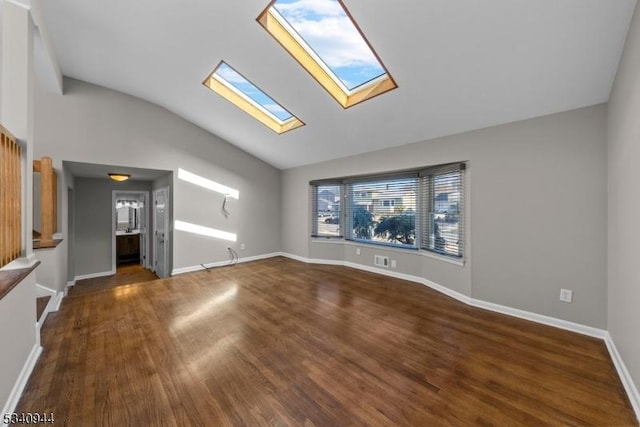 unfurnished living room featuring vaulted ceiling with skylight, baseboards, and wood finished floors