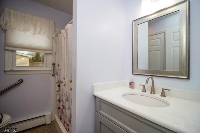 bathroom with curtained shower, toilet, a baseboard heating unit, vanity, and wood finished floors