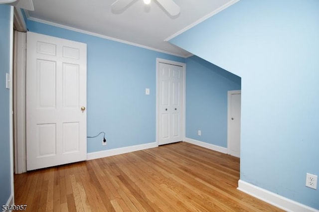 additional living space with baseboards, a ceiling fan, and light wood-style floors