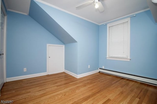 additional living space featuring baseboard heating, light wood-style floors, vaulted ceiling, ceiling fan, and baseboards