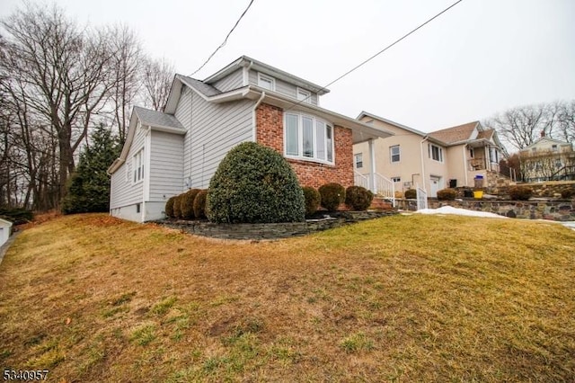 view of home's exterior featuring a yard and brick siding