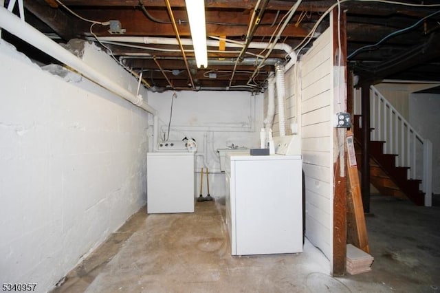 unfinished below grade area featuring stairs and separate washer and dryer