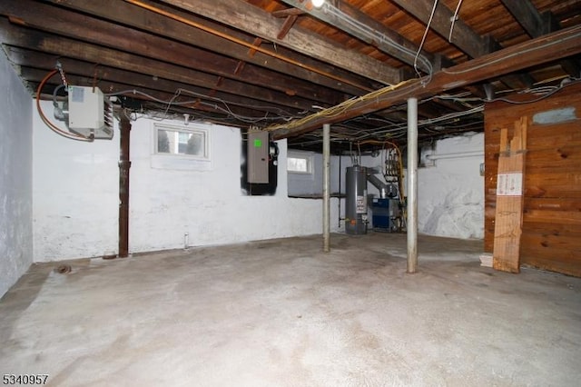 basement featuring electric panel and water heater