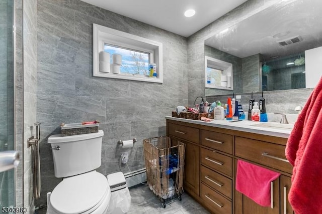 bathroom featuring toilet, visible vents, tile walls, and vanity