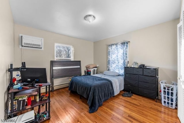 bedroom featuring a baseboard radiator and light wood finished floors