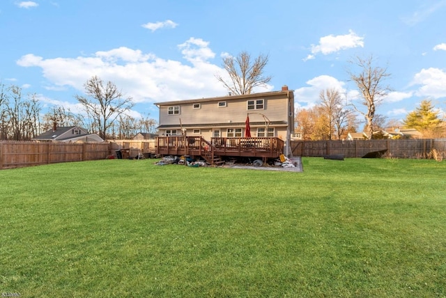 rear view of house featuring a fenced backyard, a yard, and a deck