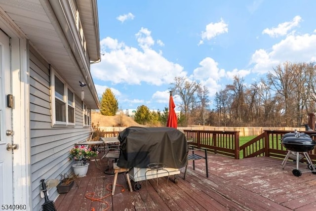 wooden deck with a grill and fence