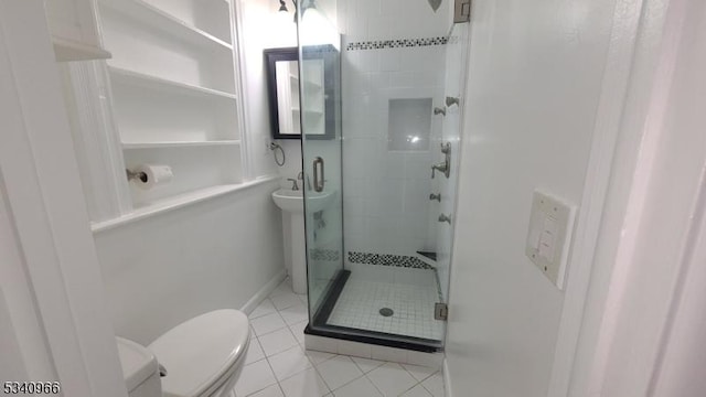 bathroom featuring a sink, tile patterned flooring, a shower stall, and toilet