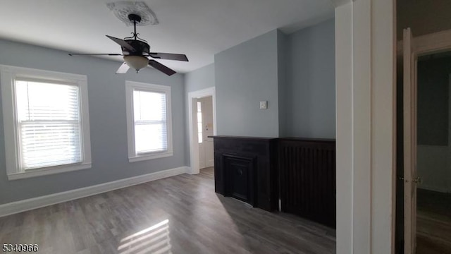 unfurnished living room with baseboards, ceiling fan, and wood finished floors