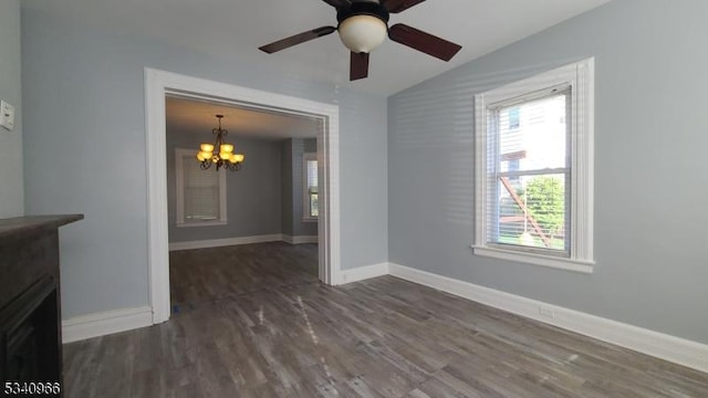 interior space featuring baseboards, ceiling fan with notable chandelier, wood finished floors, and vaulted ceiling