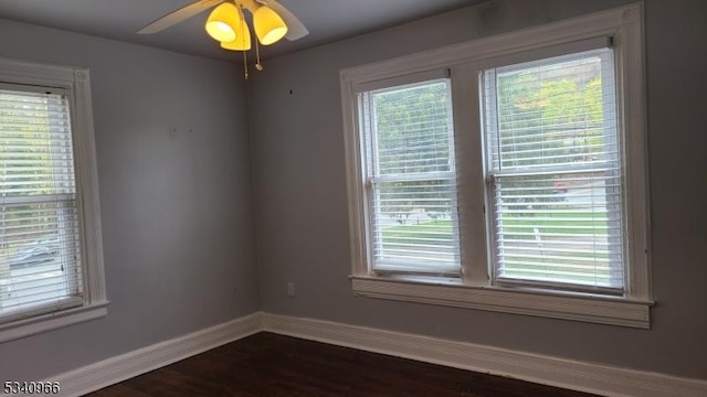 unfurnished room with dark wood-style flooring, baseboards, and ceiling fan