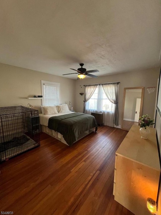 bedroom featuring radiator heating unit, ceiling fan, and dark wood-type flooring