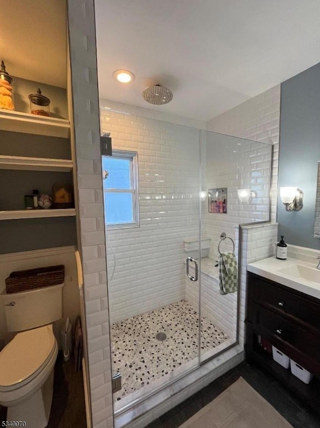 full bathroom with toilet, a stall shower, and vanity