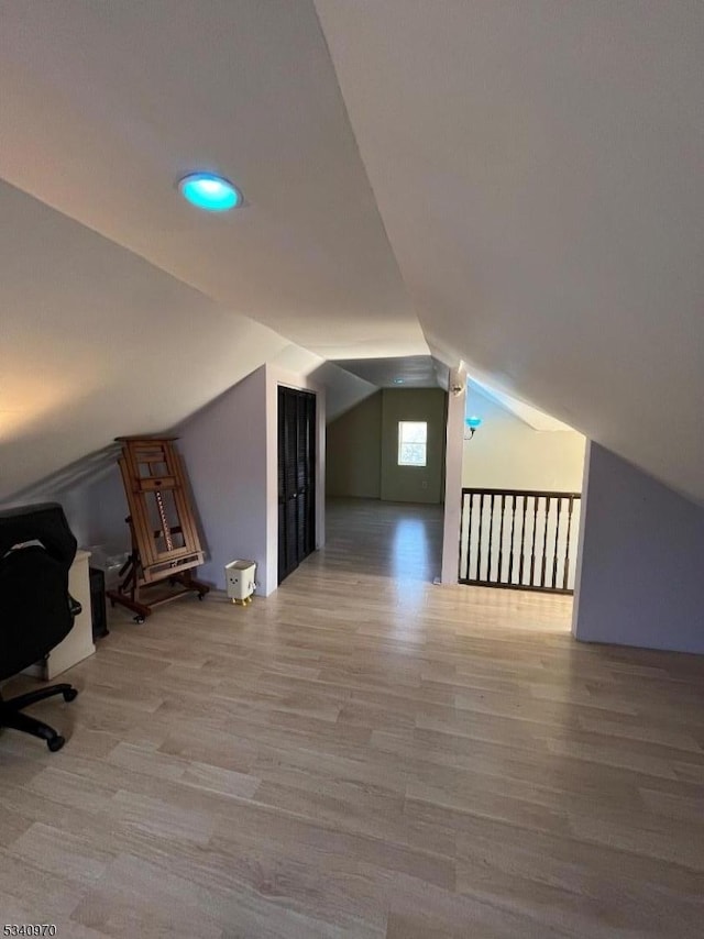 additional living space with vaulted ceiling and wood finished floors