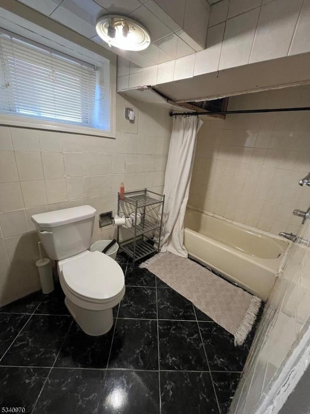 full bathroom featuring shower / bath combo, tile walls, and toilet