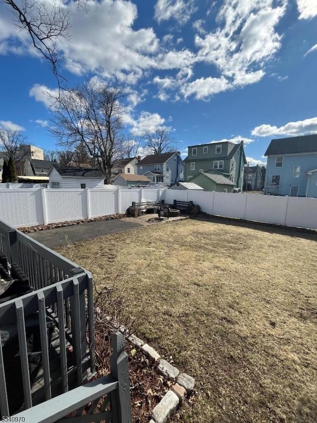 view of yard featuring a fenced backyard and a residential view