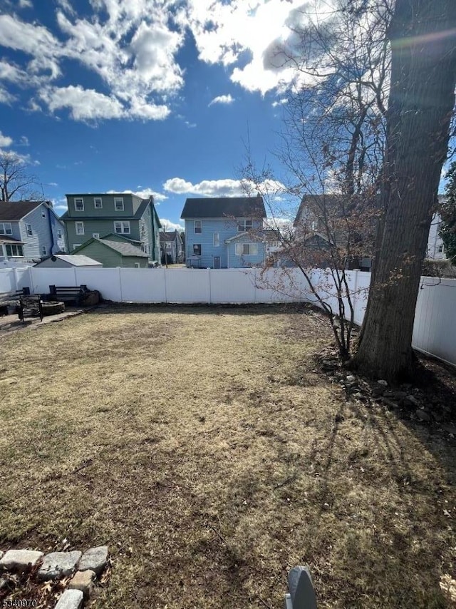 view of yard with a fenced backyard and a residential view