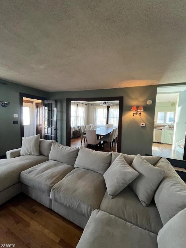 living area with a textured ceiling and wood finished floors