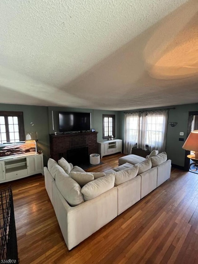 living area featuring a textured ceiling, dark wood-style flooring, and a wealth of natural light