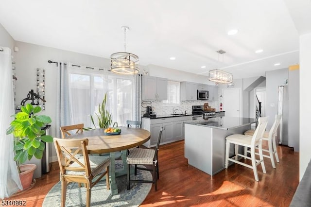 kitchen with dark countertops, appliances with stainless steel finishes, a wealth of natural light, and a center island