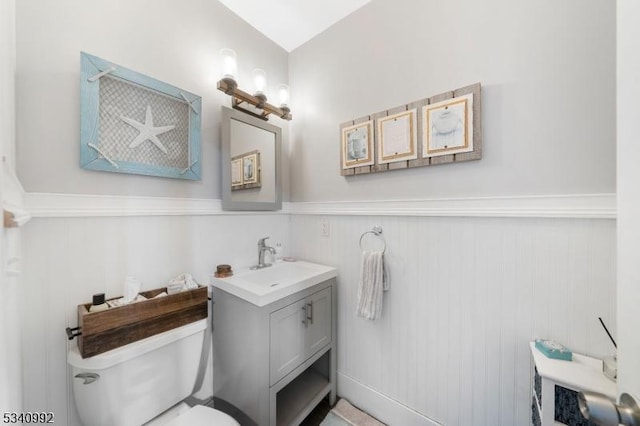 bathroom featuring wainscoting, vanity, and toilet