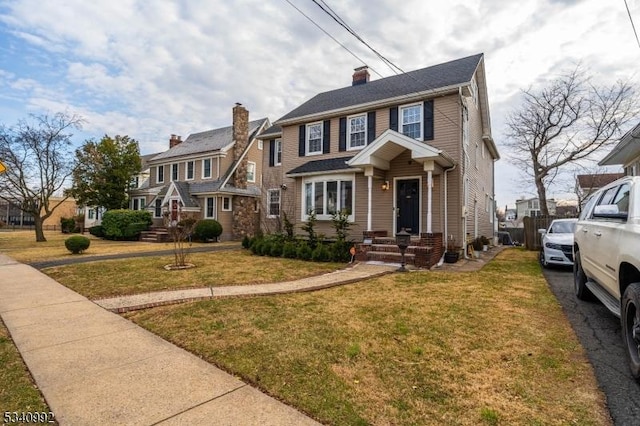 view of front of property featuring a front yard, a residential view, and a chimney