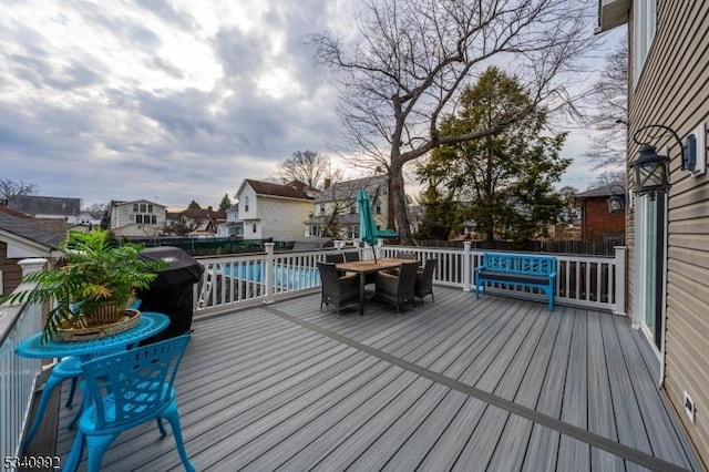 deck with fence, a fenced in pool, and outdoor dining space