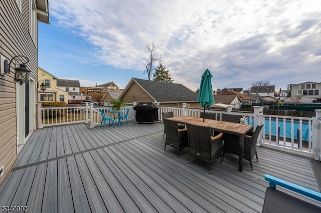 wooden deck featuring a grill and outdoor dining area