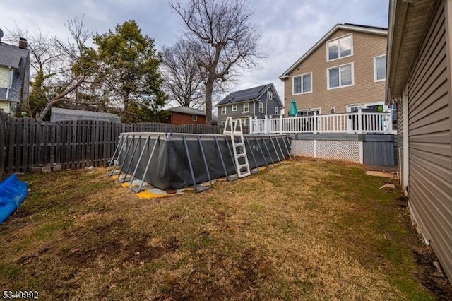 view of yard with a wooden deck, a fenced backyard, and a fenced in pool