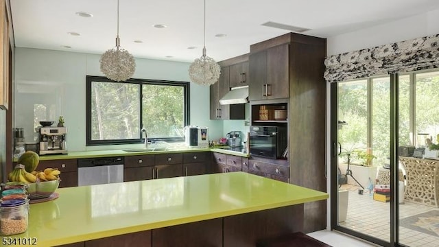 kitchen featuring pendant lighting, light countertops, a sink, dishwasher, and under cabinet range hood